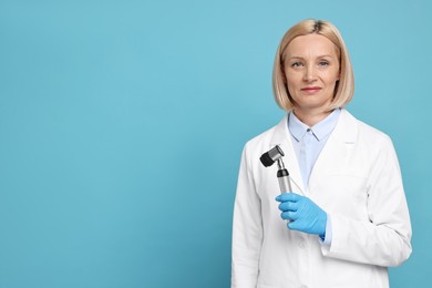 Dermatologist with dermatoscope on light blue background, space for text