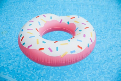 Inflatable ring floating on water in swimming pool