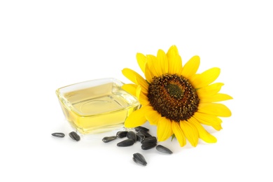 Sunflower, oil in glass bowl and seeds on white background