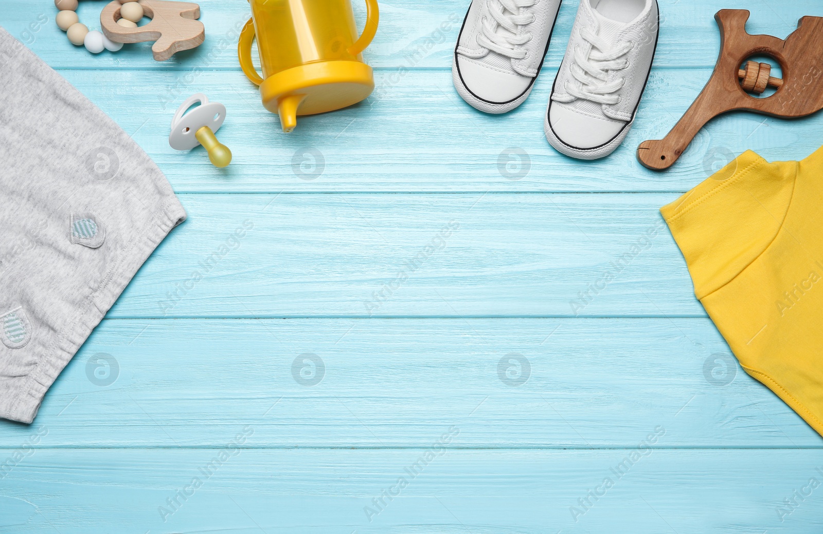 Photo of Baby clothes and accessories on light blue wooden background, flat lay. Space for text