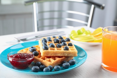 Photo of Delicious waffles with blueberries and juice on white table