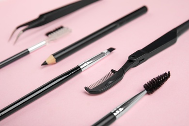 Photo of Set of professional eyebrow tools on pink background
