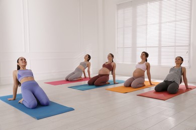 Photo of Trainer working with group of pregnant women in gym. Preparation for child birth