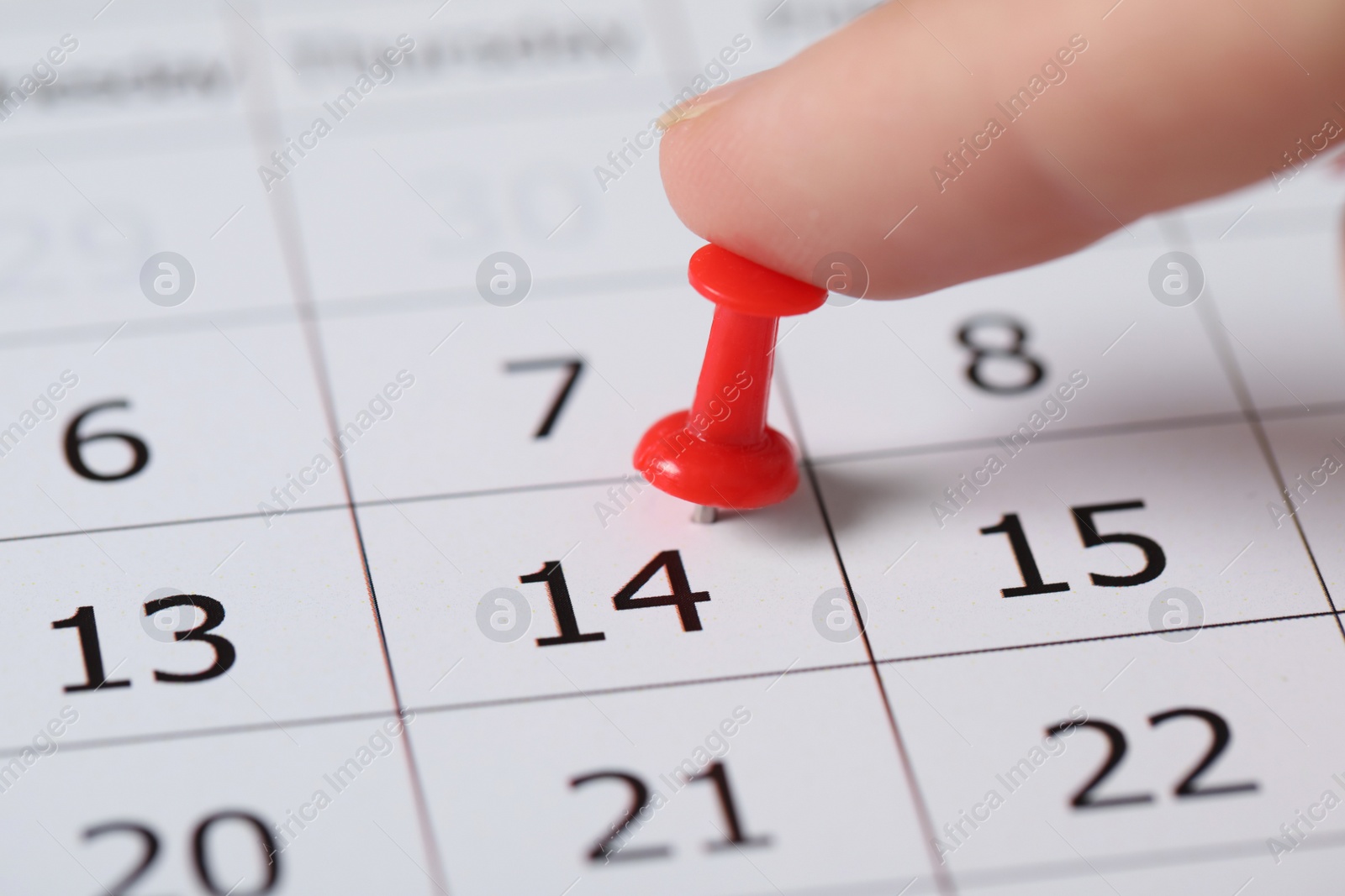 Photo of Woman marking Valentine's Day on calendar, closeup