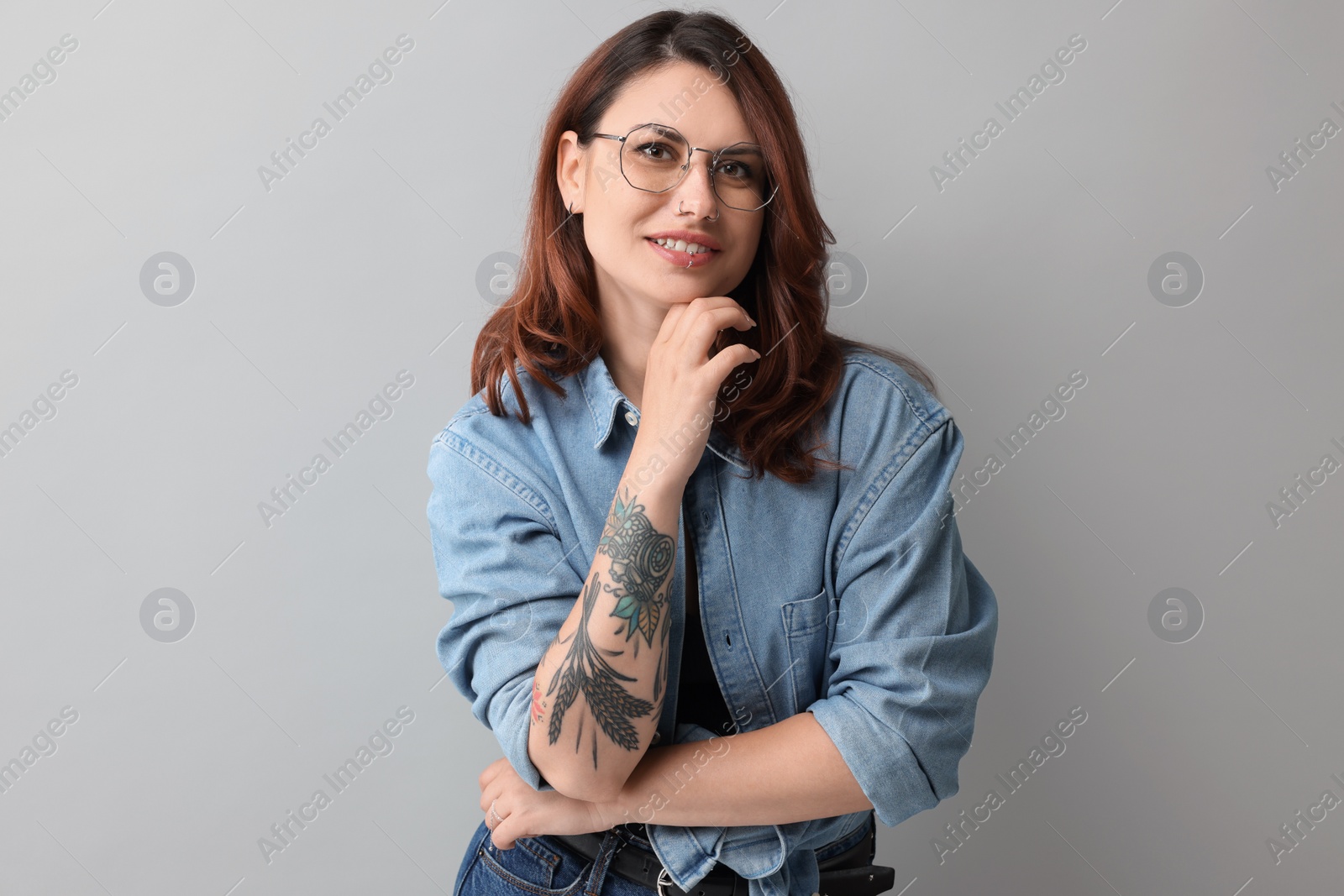 Photo of Portrait of beautiful tattooed woman on gray background