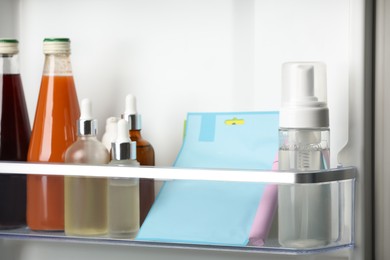 Different cosmetic products on shelf in refrigerator