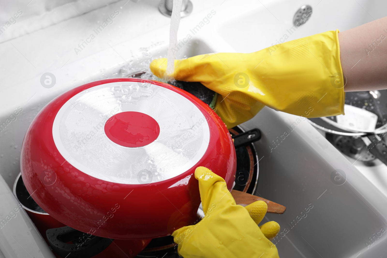 Photo of Woman washing frying pan in kitchen sink, above view