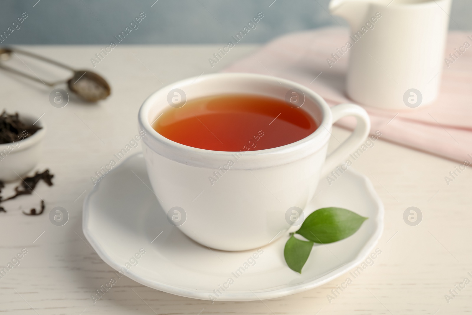 Photo of Cup of delicious tea with saucer on table