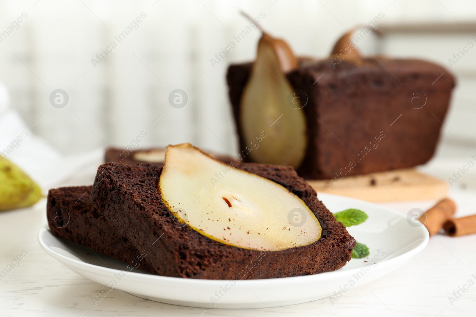 Photo of Tasty pear bread served with mint on white wooden table. Homemade cake