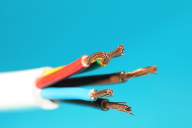 Electrical wires on light blue background, closeup