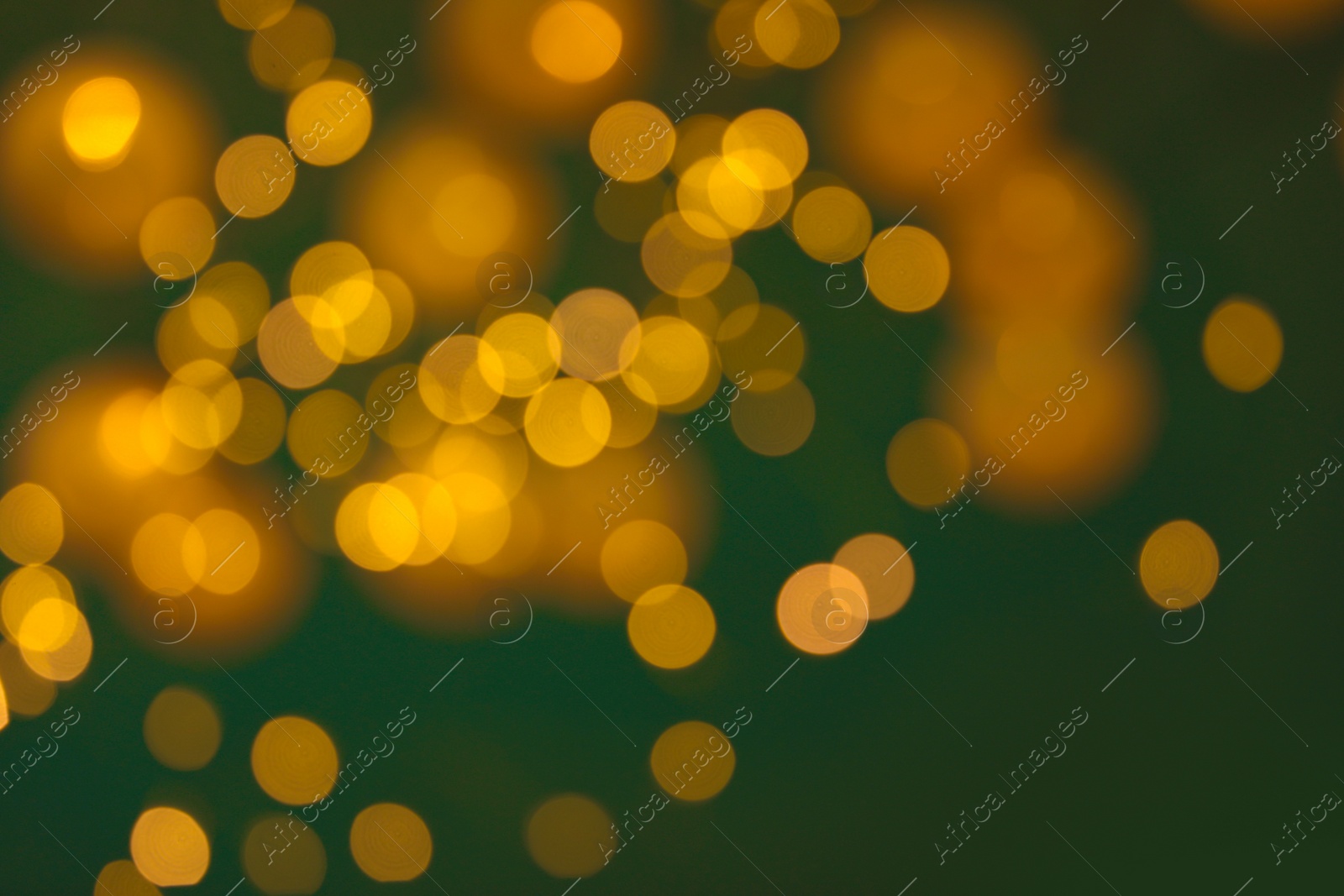 Photo of Blurred view of gold lights on dark background. Bokeh effect