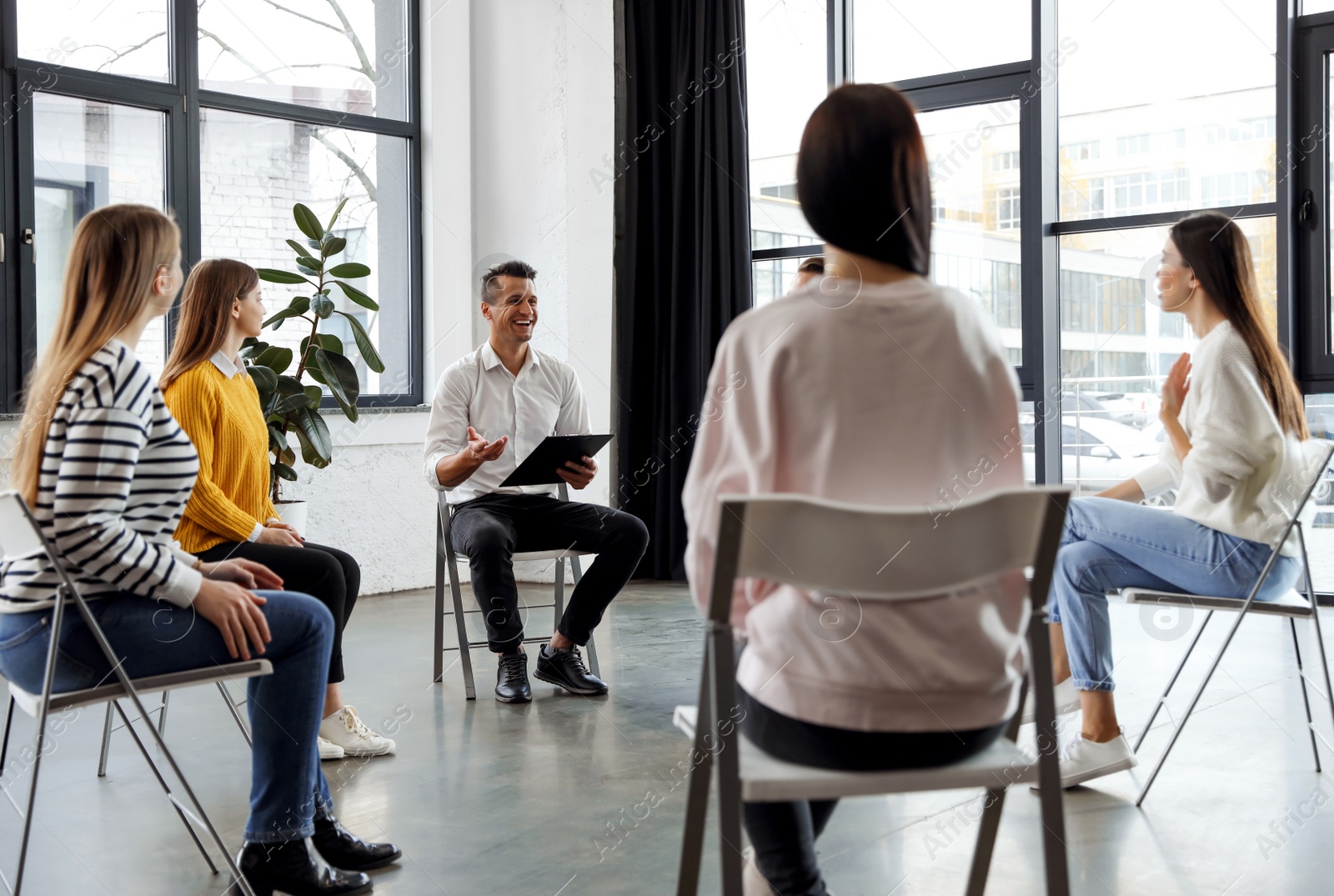 Photo of Psychotherapist working with patients in group therapy session indoors