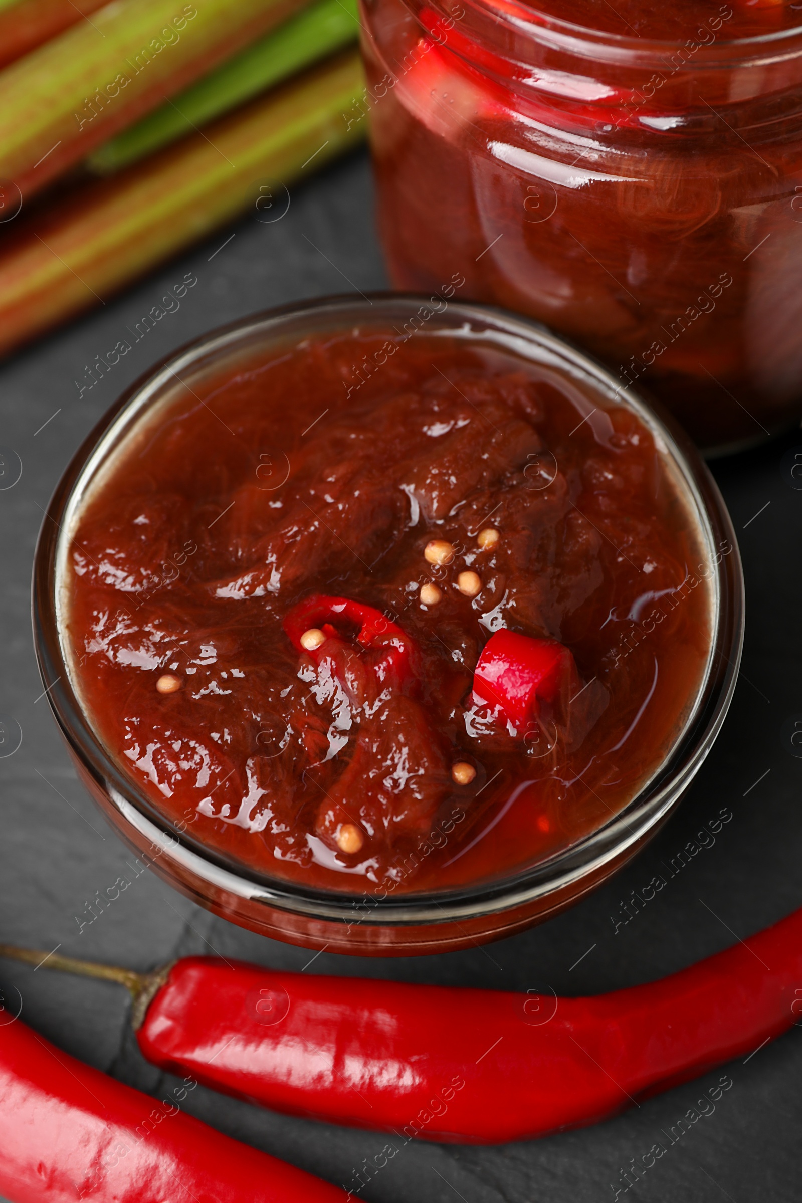 Photo of Tasty rhubarb sauce and ingredients on black table