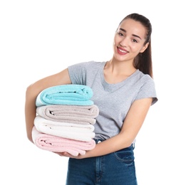 Happy young woman holding clean towels on white background. Laundry day