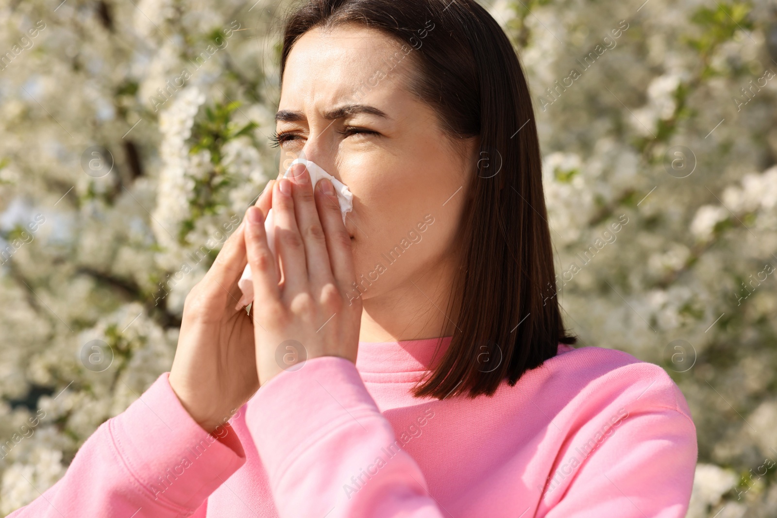 Photo of Woman with napkin suffering from seasonal allergy on spring day