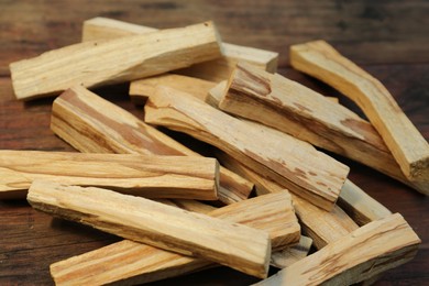 Many palo santo sticks on wooden table, closeup