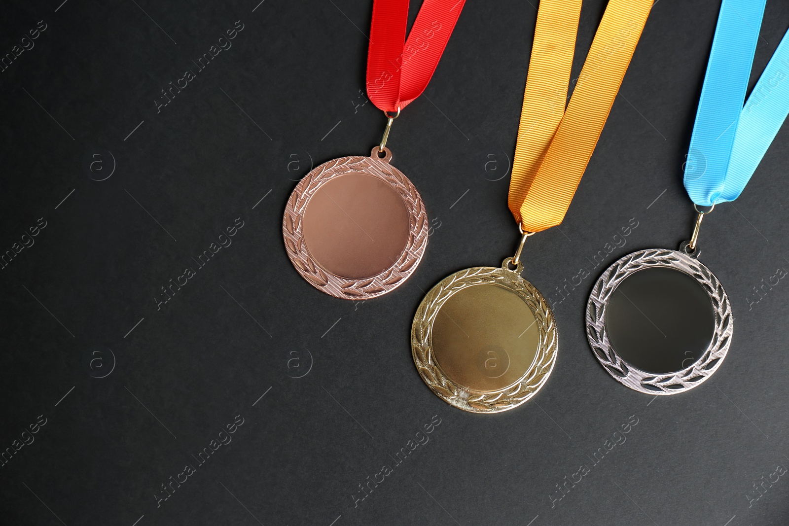 Photo of Gold, silver and bronze medals on black background, flat lay. Space for design