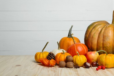 Photo of Happy Thanksgiving day. Beautiful composition with pumpkins on wooden table, space for text