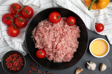 Raw chicken minced meat and ingredients on black table, flat lay