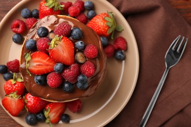 Photo of Stack of tasty pancakes with fresh berries and chocolate spread on table, flat lay