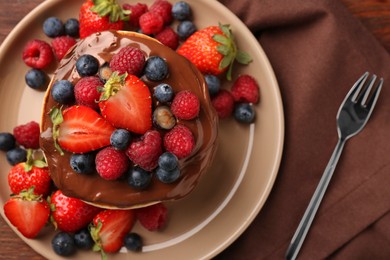 Stack of tasty pancakes with fresh berries and chocolate spread on table, flat lay