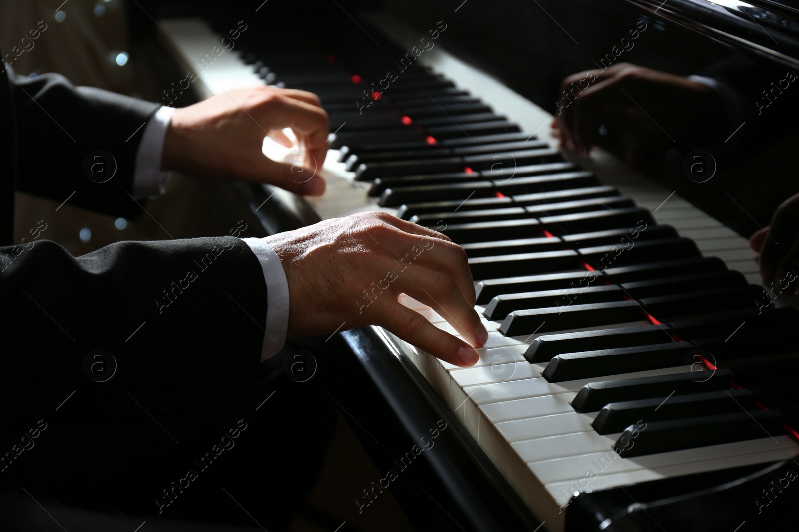 Photo of Man playing grand piano, closeup. Talented musician