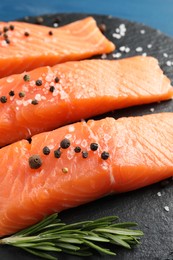 Photo of Fresh raw salmon and ingredients for marinade on slate board, closeup
