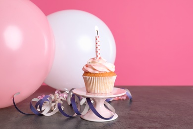 Photo of Composition with birthday cupcake and balloons on table. Space for text