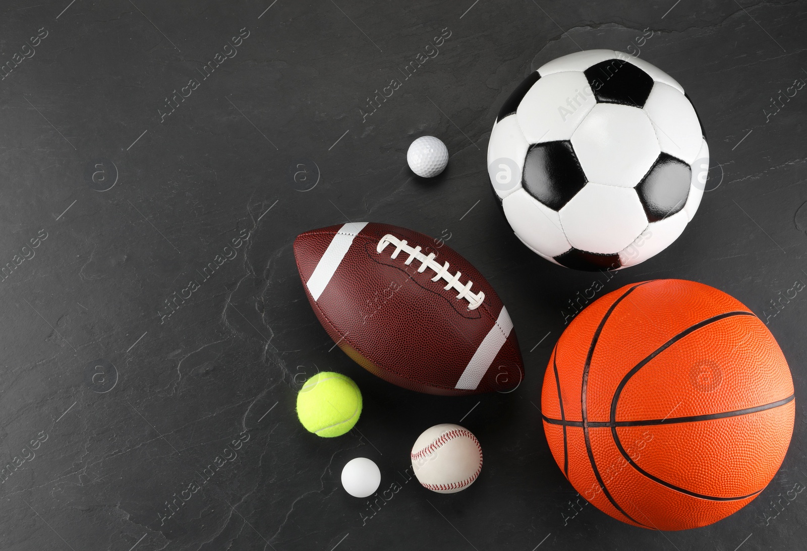 Photo of Many different sports balls on dark gray background, flat lay. Space for text