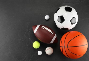 Many different sports balls on dark gray background, flat lay. Space for text