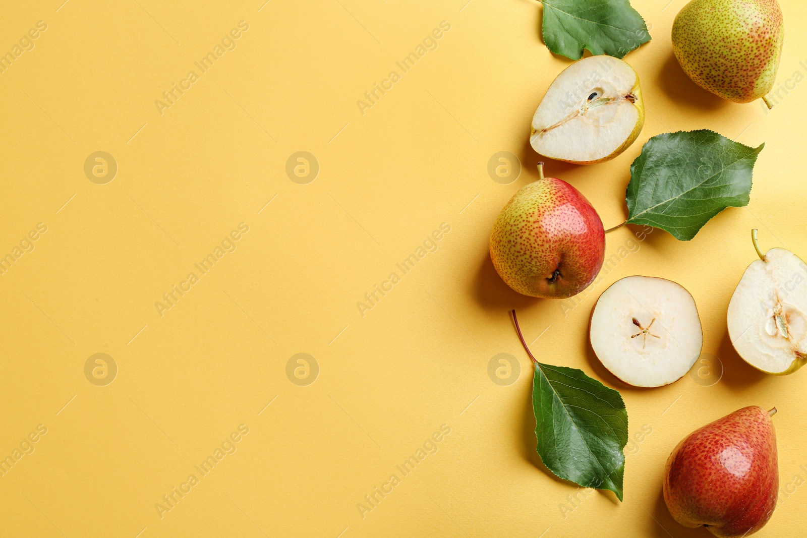 Photo of Ripe juicy pears on yellow background, flat lay. Space for text