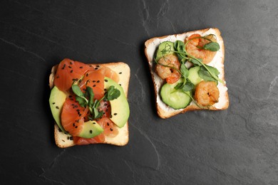 Photo of Tasty toasts with different toppings on black table, flat lay