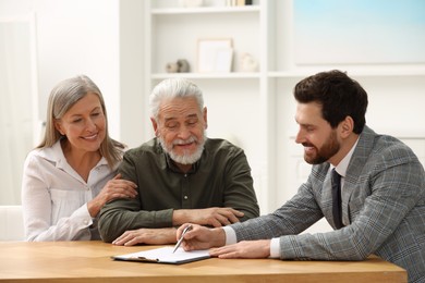 Notary consulting senior couple about Last Will and Testament in office