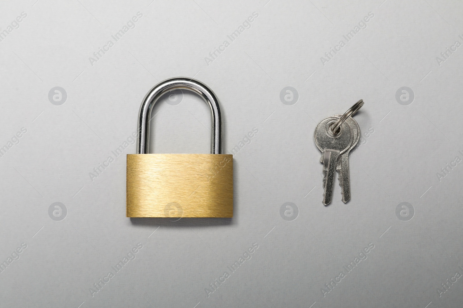 Photo of Steel padlock with keys on grey background, top view