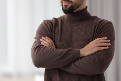 Man in stylish sweater against blurred background, closeup
