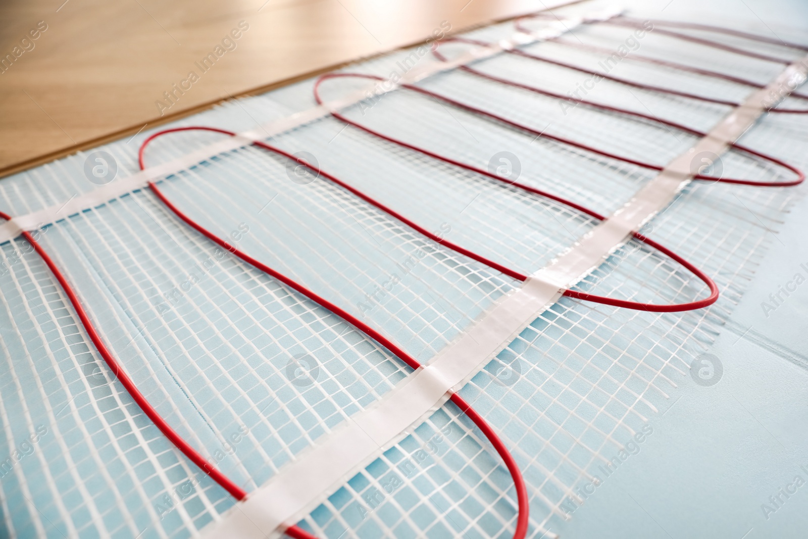 Photo of Installation of modern underfloor trace heating system indoors, closeup