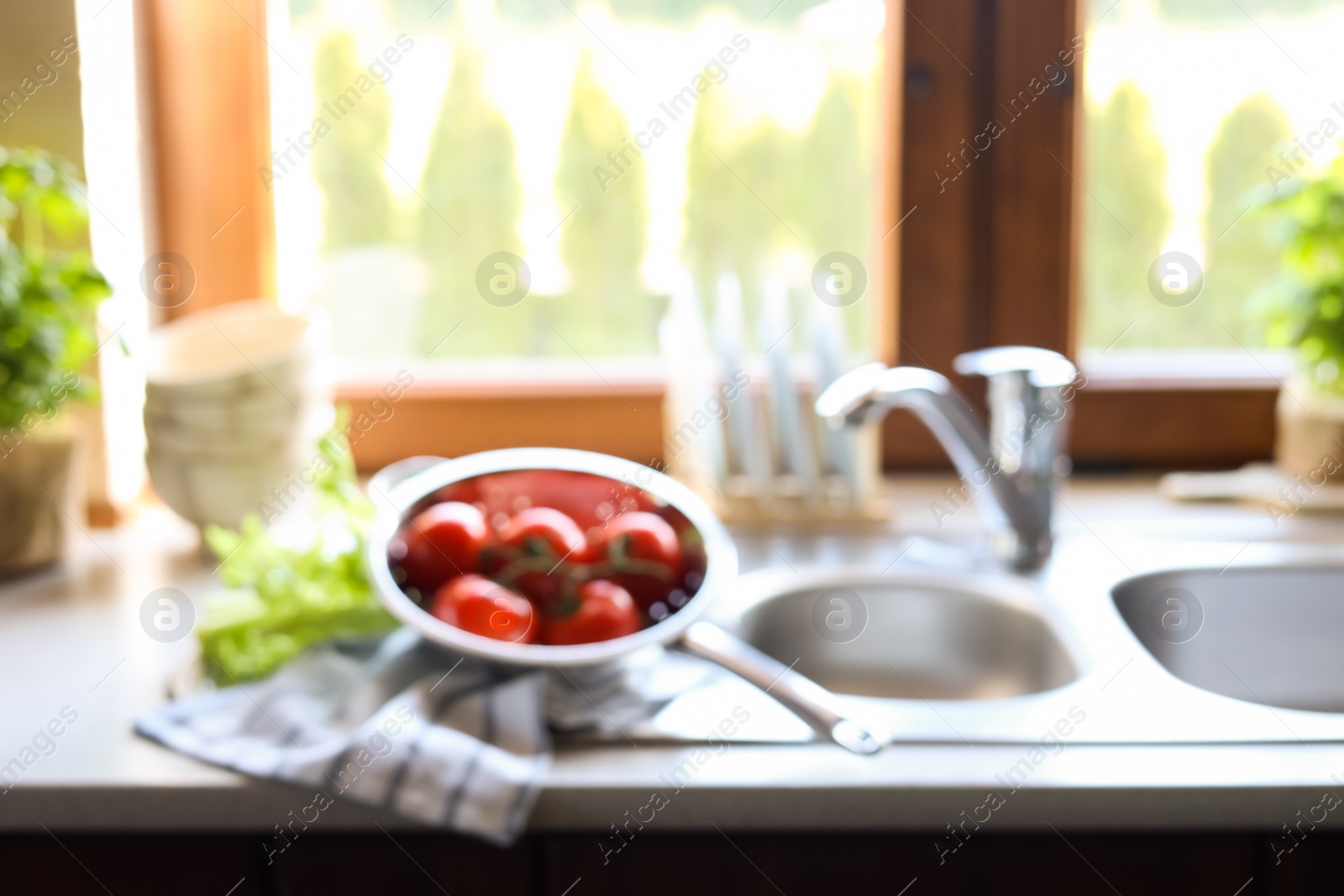 Photo of Blurred view of stylish kitchen interior with sink and products