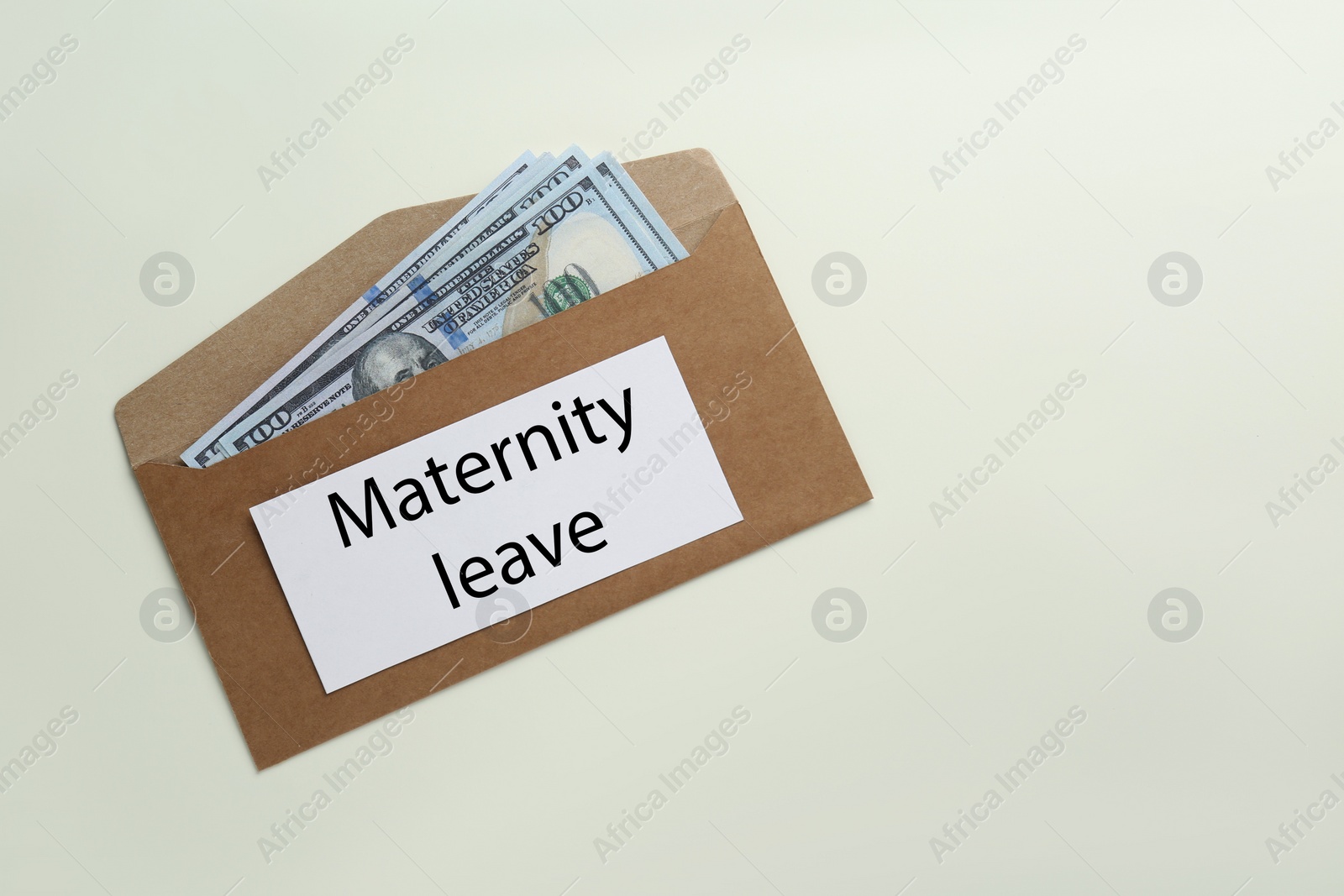 Photo of Maternity leave concept. Envelope with dollar banknotes and note on white background, top view. Space for text