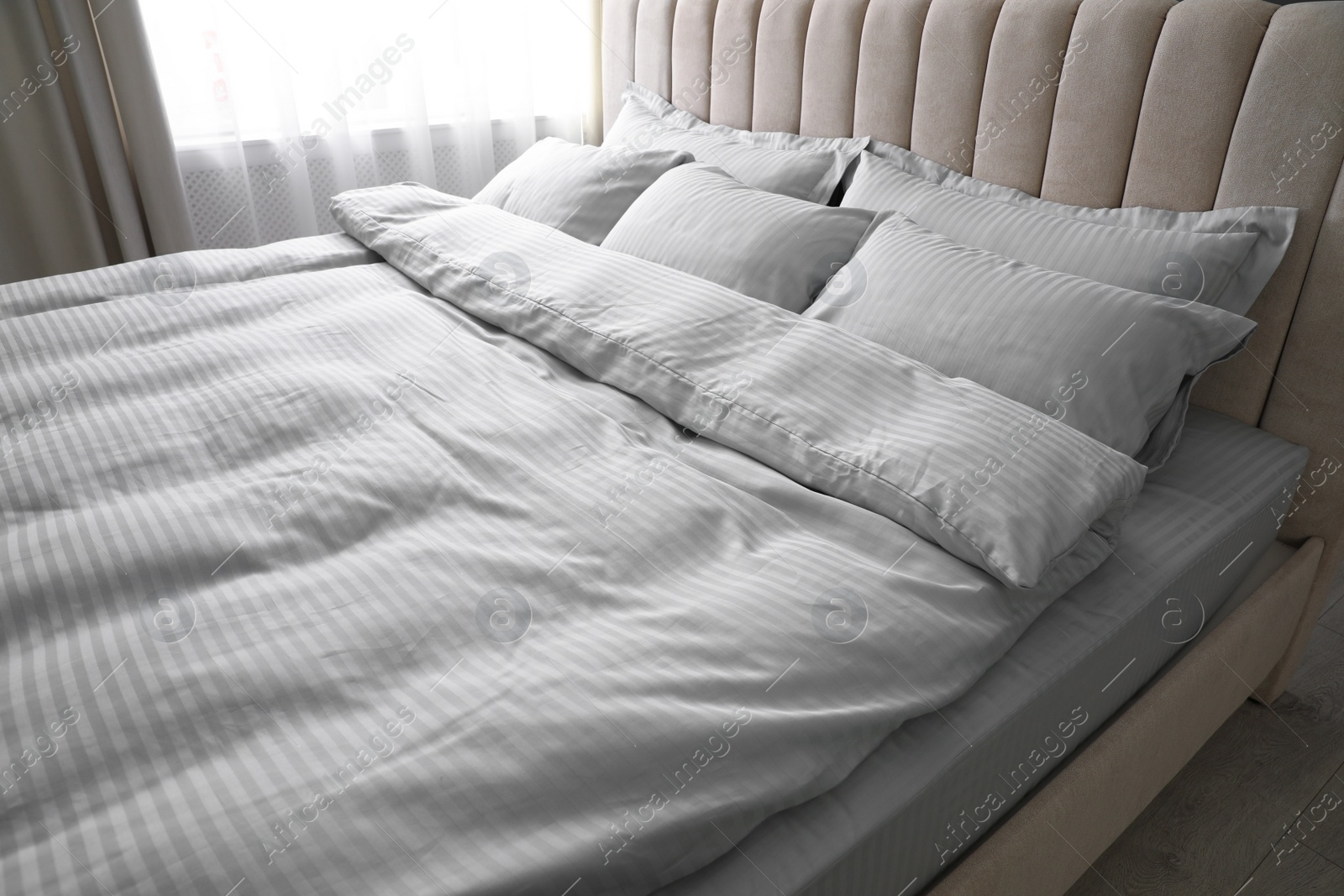 Photo of Comfortable bed with soft blanket and pillows indoors