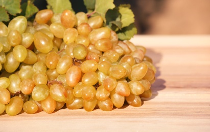 Photo of Fresh ripe juicy grapes on wooden table
