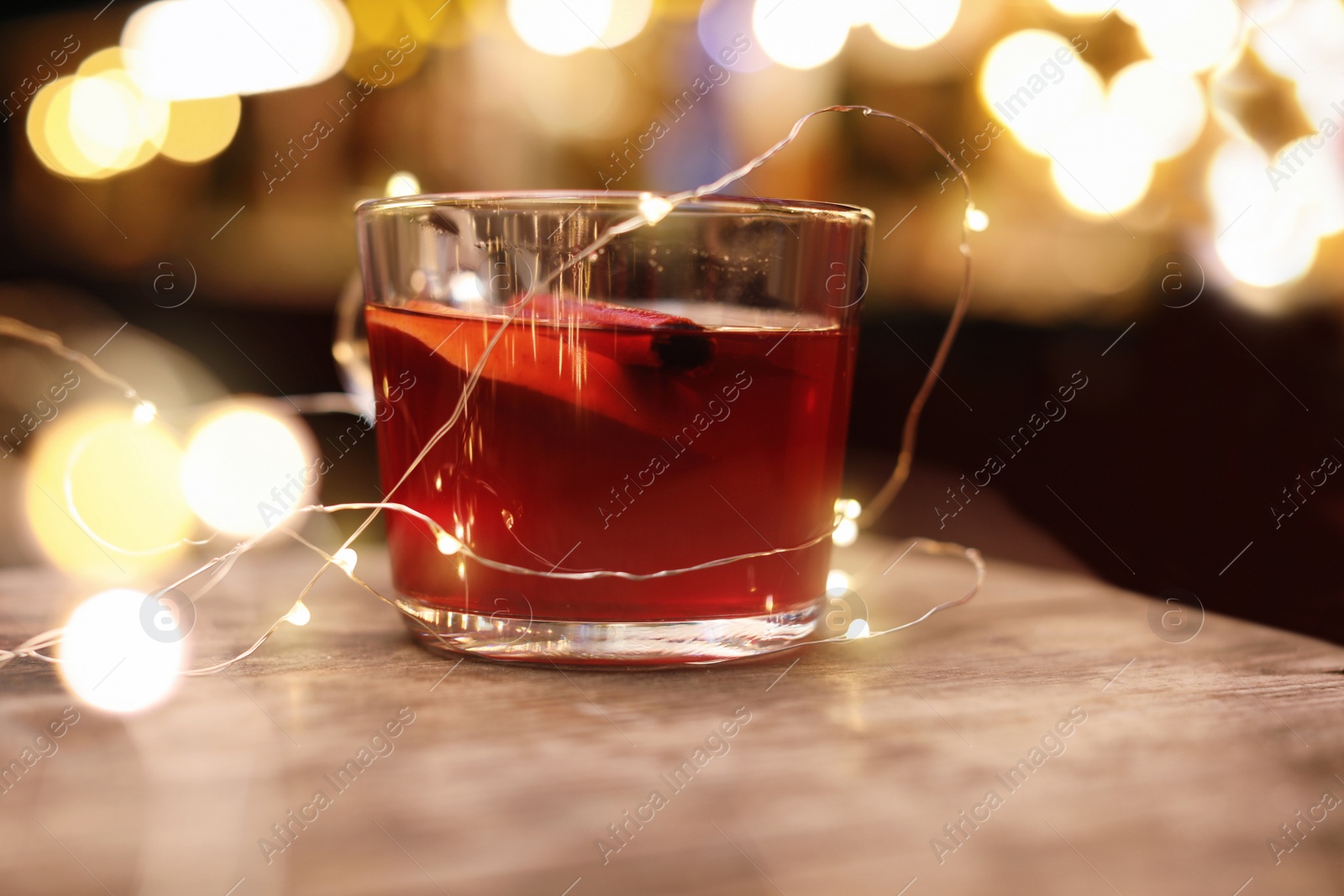 Photo of Tasty aromatic mulled wine on wooden table