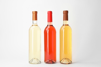 Bottles of expensive wines on light background