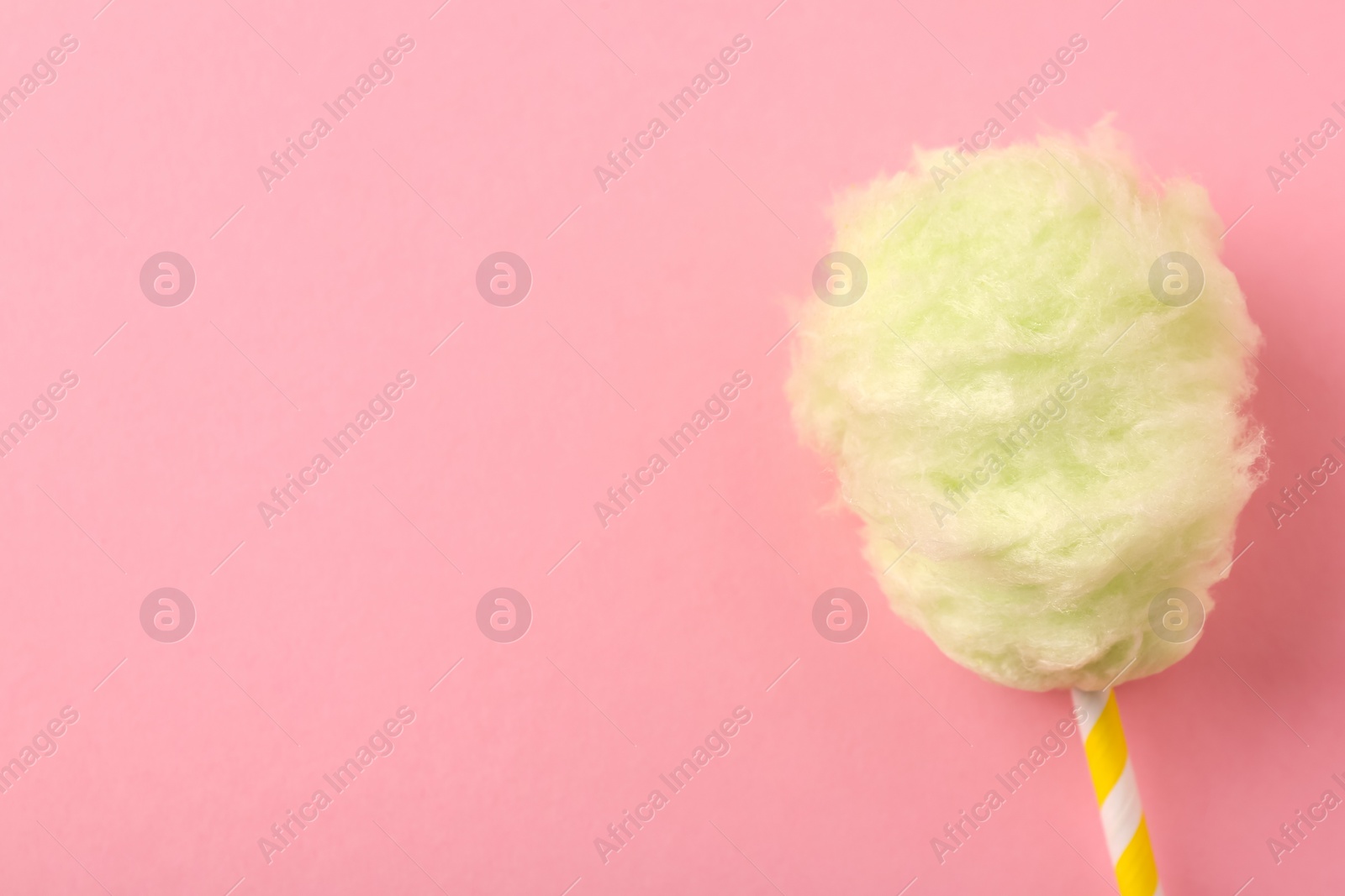 Photo of Sweet cotton candy on pink background, top view. Space for text