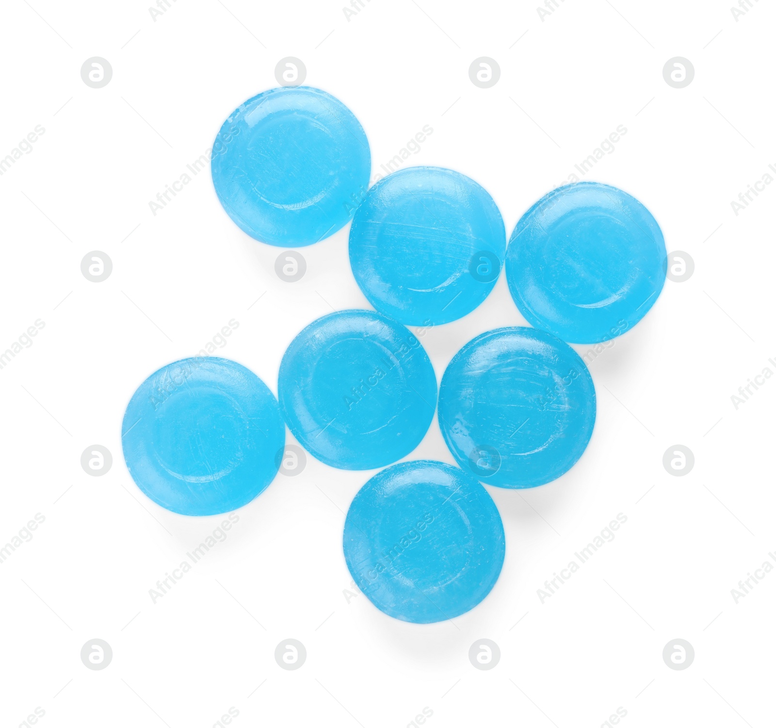 Photo of Many light blue cough drops on white background, top view