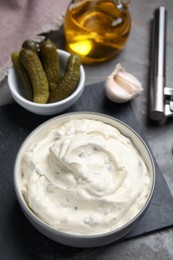 Tasty tartar sauce and ingredients on grey table