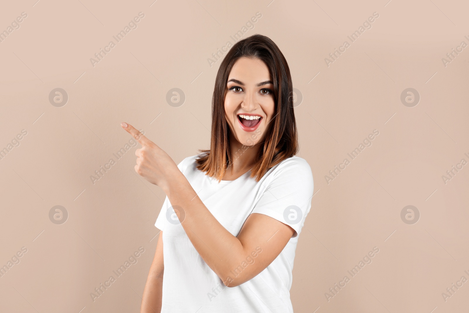 Photo of Happy beautiful young woman on beige background