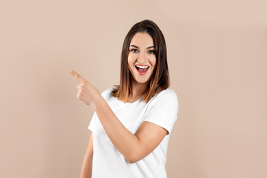 Photo of Happy beautiful young woman on beige background