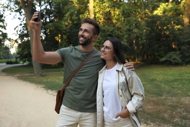 Lovely couple taking selfie together in nature reserve