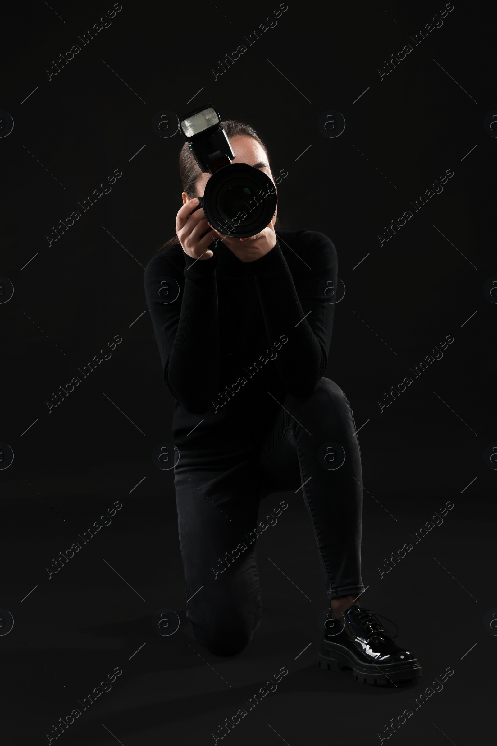 Photo of Professional photographer taking picture on black background