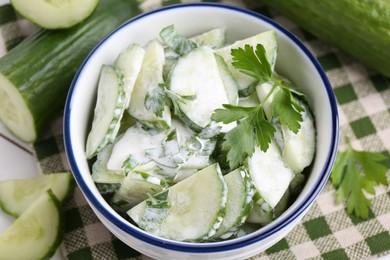 Delicious cucumber salad in bowl on table, closeup